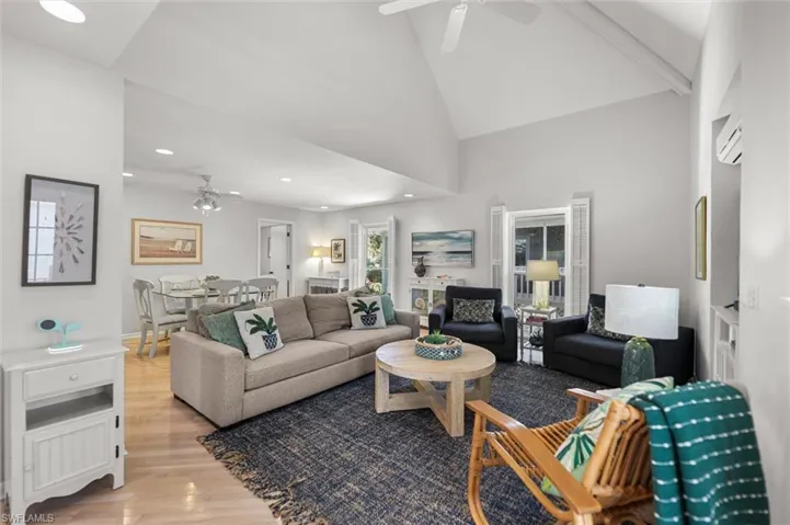 Living room with ceiling fan, light wood-style flooring, recessed lighting, and vaulted ceiling