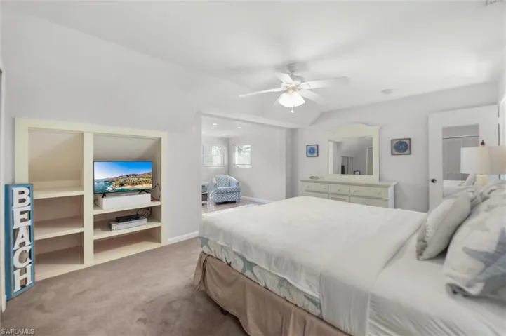Bedroom featuring carpet floors, a ceiling fan, and vaulted ceiling