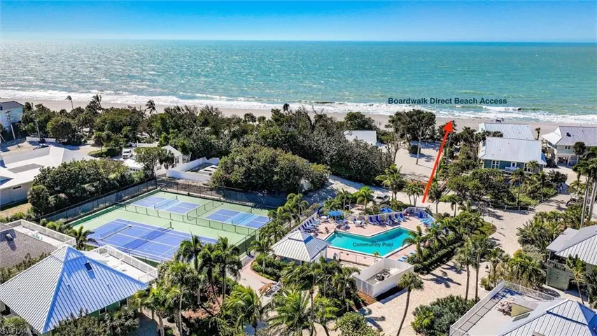 Aerial view of residential area with waterfront with a beach and a pool