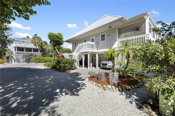 Coastal home with a carport, a metal roof, driveway, and a ceiling fan