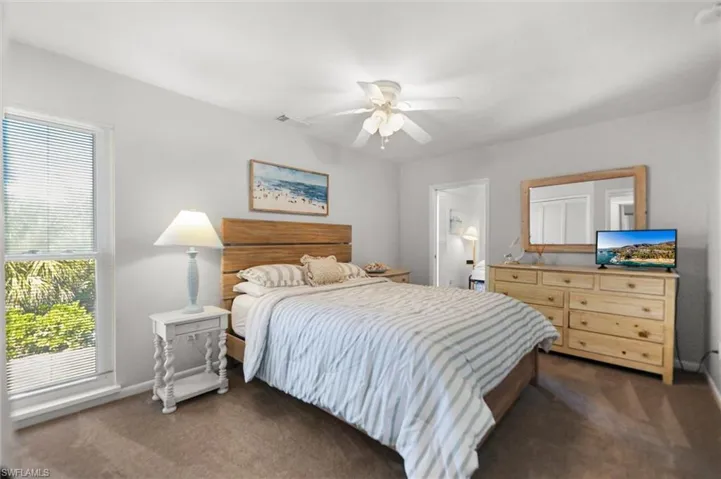 Bedroom with dark carpet and ceiling fan