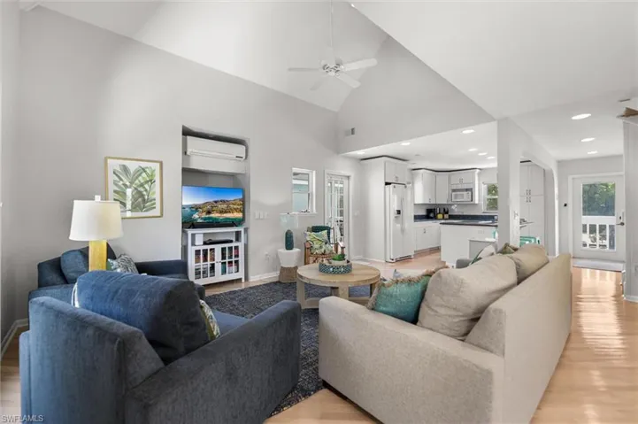 Living room featuring light wood-type flooring, a ceiling fan, and vaulted ceiling