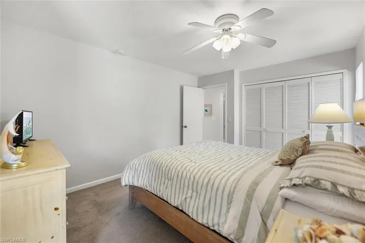 Bedroom featuring dark colored carpet, a closet, and ceiling fan