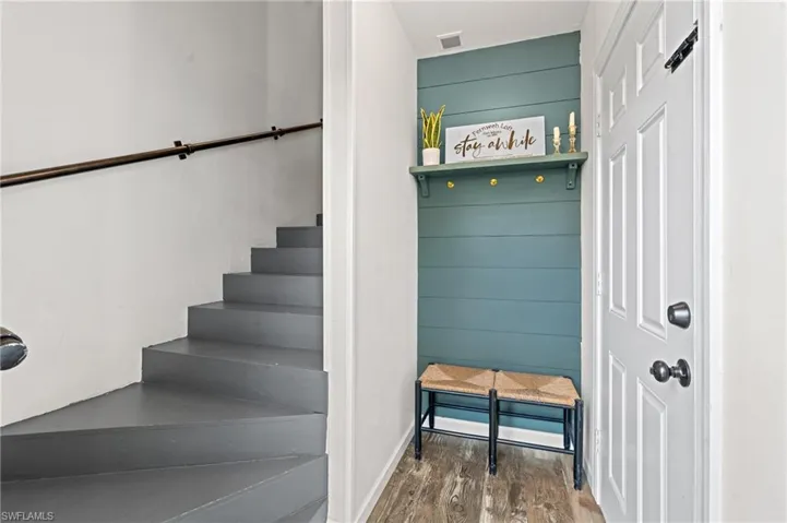 Stairway featuring wood finished floors and visible vents