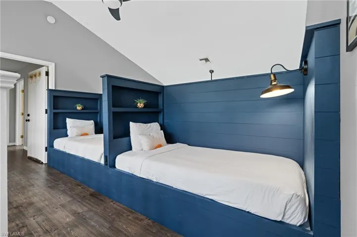 Bedroom with visible vents, wood finished floors, ceiling fan, and lofted ceiling