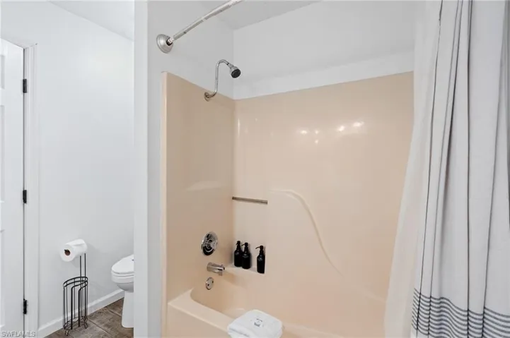 Full bath with shower / bath combo with shower curtain and toilet