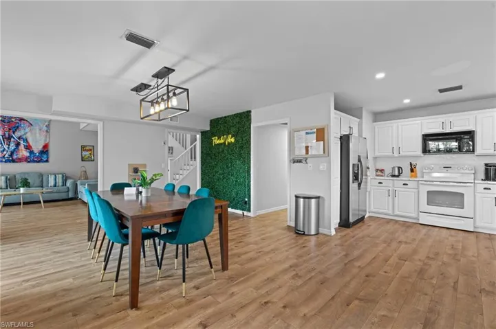 Dining room with recessed lighting, an inviting chandelier, stairway, visible vents, and light wood-style flooring