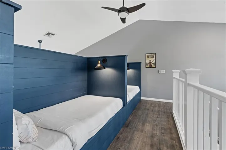 Bedroom with wood finished floors, baseboards, visible vents, a ceiling fan, and lofted ceiling