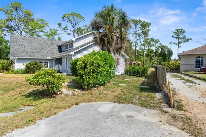 View of property exterior featuring a yard and fence
