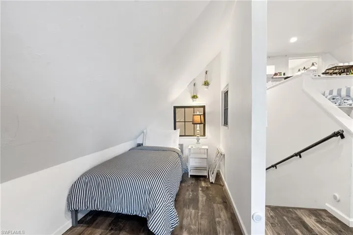 Bedroom featuring baseboards, recessed lighting, wood finished floors, and vaulted ceiling