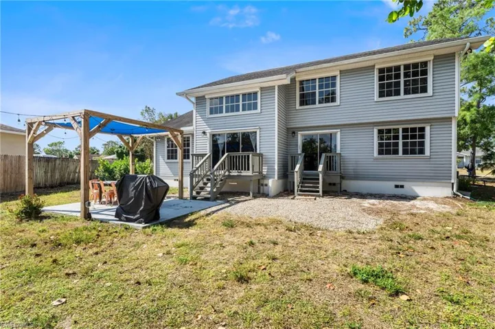 Back of house with a lawn, crawl space, fence, and a patio area