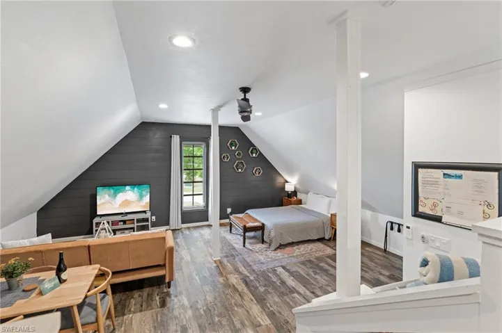 Bedroom with baseboards, recessed lighting, wood finished floors, and lofted ceiling