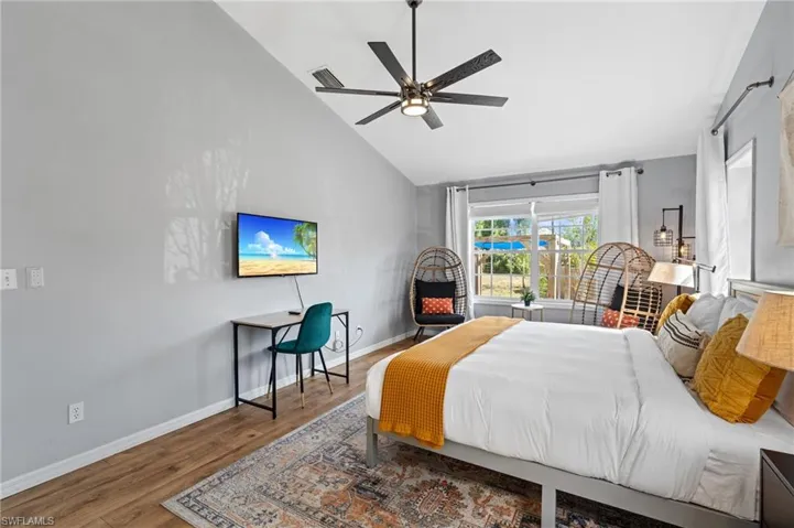 Bedroom featuring visible vents, high vaulted ceiling, wood finished floors, and baseboards