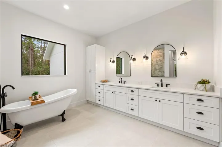Bathroom with a tub to relax in and his and her vanities