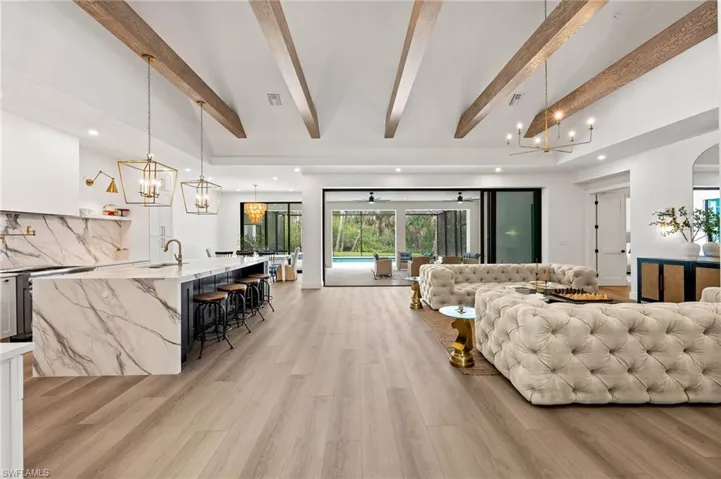 Living room with light hardwood / wood-style floors and beamed ceiling