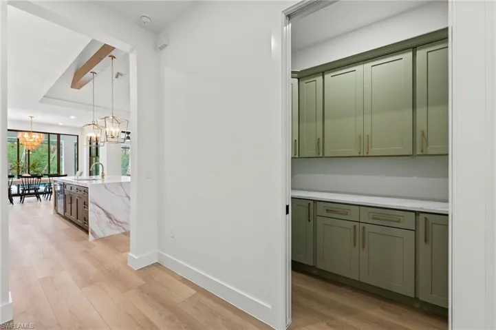 Hall to BP featuring light hardwood / wood-style floors, a chandelier, and sink