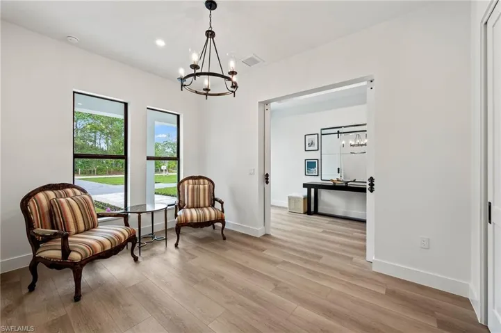 Living area featuring light wood-type flooring and an inviting chandelier