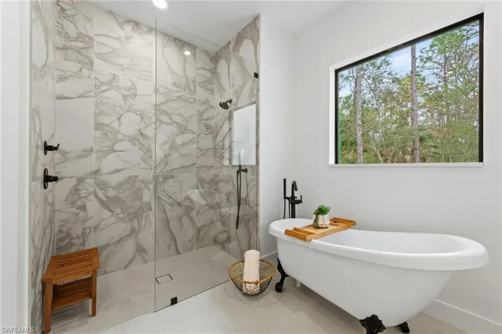 Bathroom with independent shower and bath and tile patterned flooring