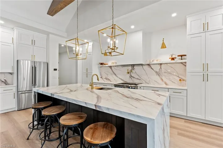 Kitchen with white cabinetry, sink and Thermador appliances with stainless steel finish