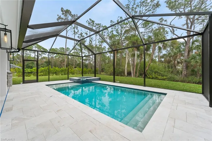View of salt water pool featuring a patio area, a lawn, a lanai, and an in ground hot tub