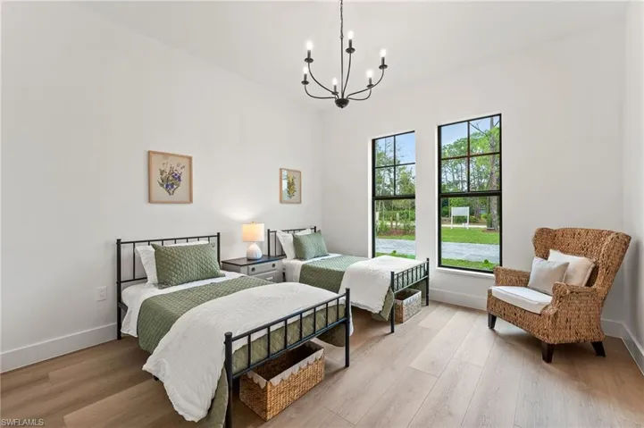 Bedroom featuring a notable chandelier and light hardwood / wood-style floors