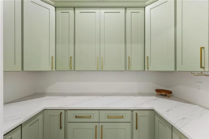 Kitchen with light color countertops and green cabinets