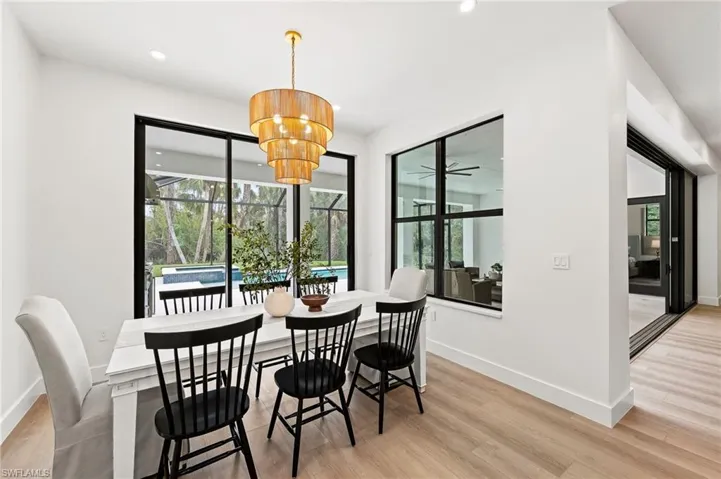 Dining space with light wood-type flooring and a notable chandelier
