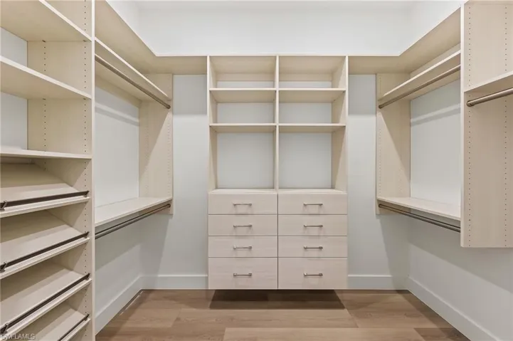 Spacious closet featuring hardwood / wood-style flooring