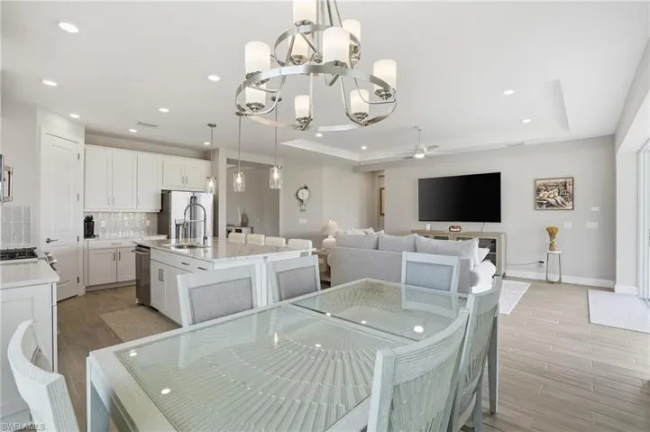 Dining space with recessed lighting, a chandelier, wood tiled floors, and ceiling fan