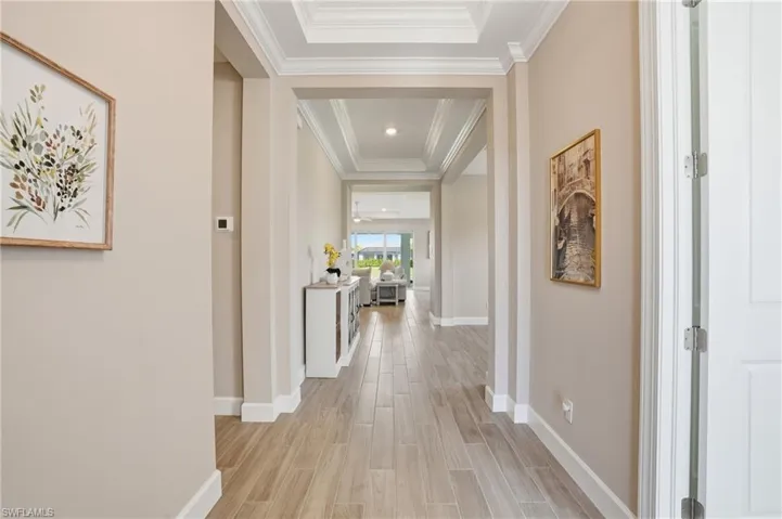 Hall featuring wood finish floors and a tray ceiling