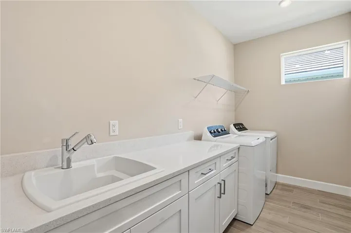 Laundry room with wood tiled floors, independent washer and dryer, and cabinet space