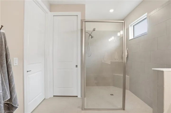 Full bathroom featuring walk in shower, light tile patterned flooring, and recessed lighting