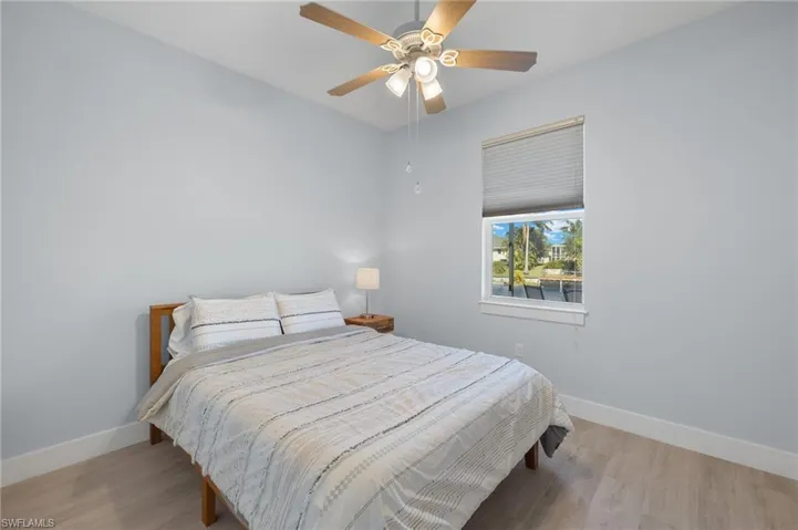 Bedroom featuring ceiling fan and light woodplank tile flooring