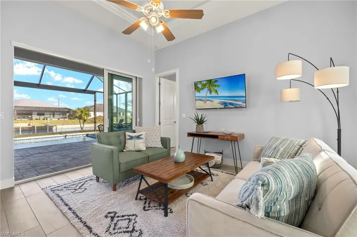 Tiled living room featuring ceiling fan and crown molding