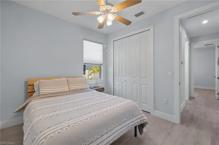 Bedroom with light woodplank tile  flooring, a closet, and ceiling fan