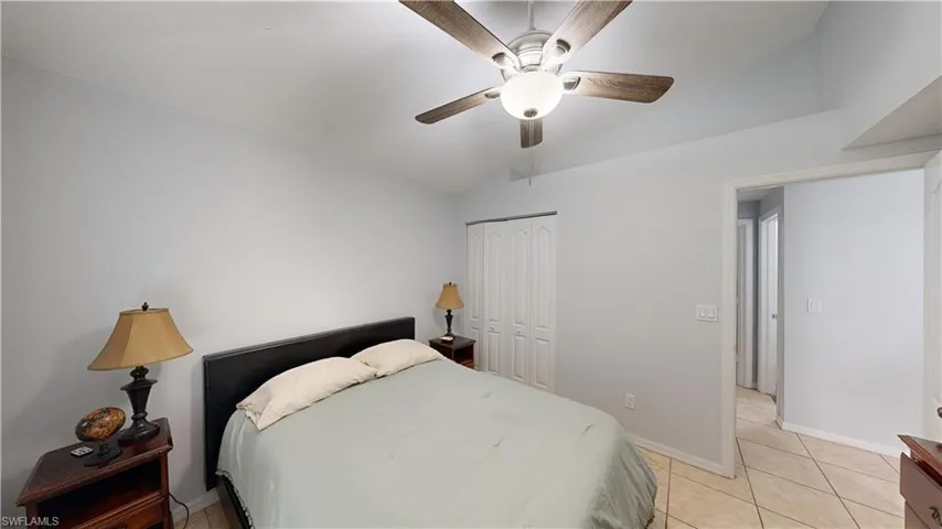 Tiled bedroom with lofted ceiling, a closet, and ceiling fan