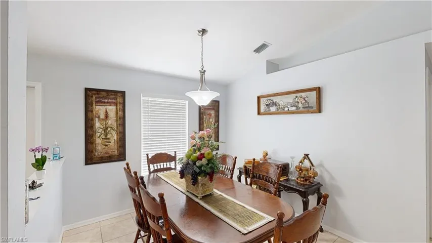 Tiled dining area with lofted ceiling