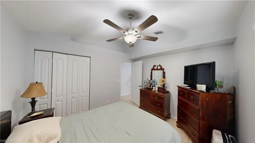 Bedroom featuring a closet, ceiling fan, and light tile patterned flooring