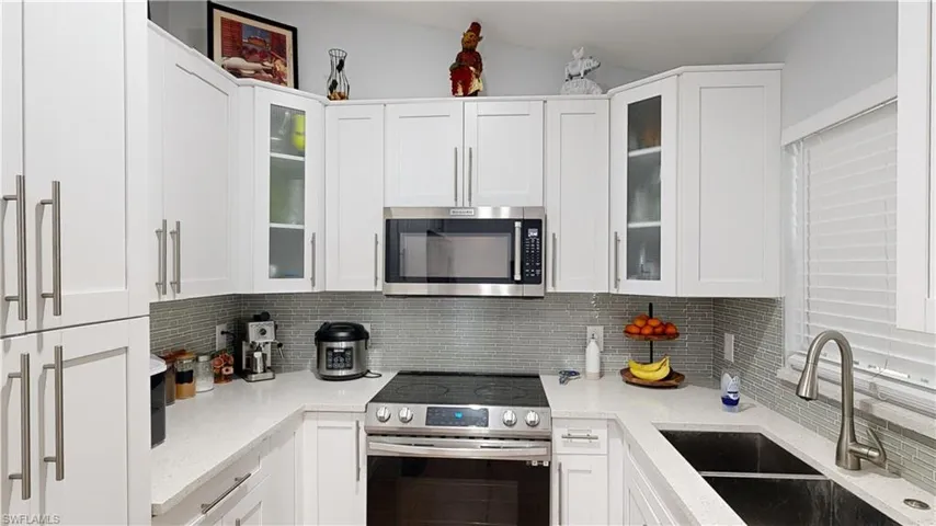 Kitchen featuring sink, appliances with stainless steel finishes, and white cabinets