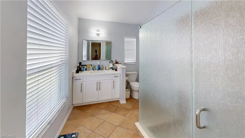 Master Bathroom with toilet, an enclosed shower, tile patterned floors, vanity, and plenty of natural light
