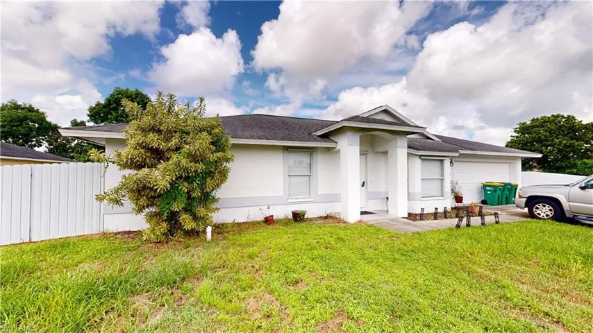 View of front facade featuring a front lawn and a garage