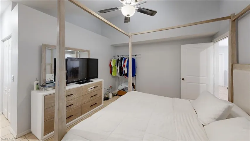M. Bedroom with vaulted ceiling, light tile patterned flooring, and ceiling fan