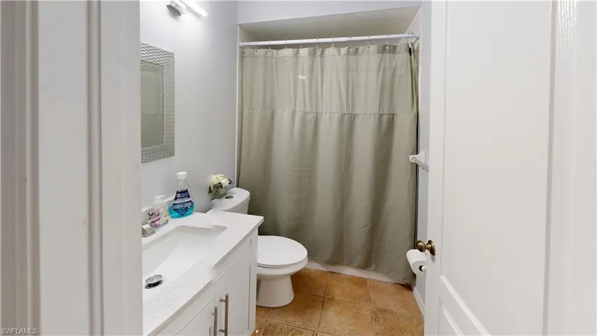 Bathroom with vanity, toilet, and tub shower combo