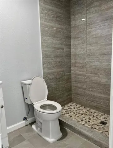 Efficiency bathroom with tiled shower and toilet