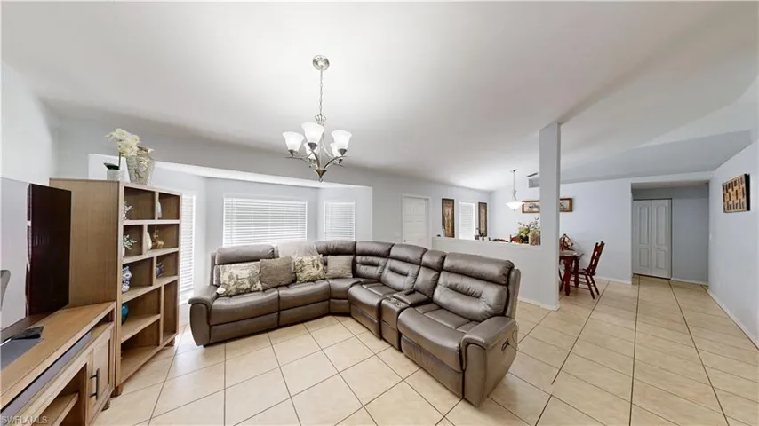 Tiled living room with lofted ceiling and an inviting chandelier