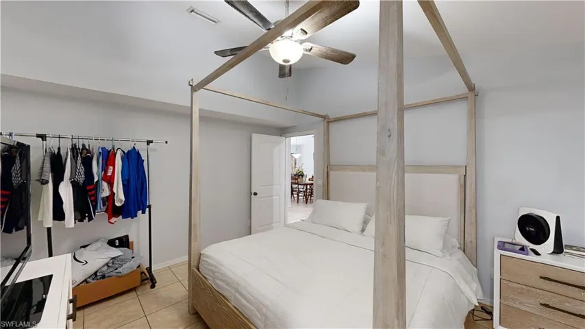 Master bedroom featuring light tile patterned flooring and ceiling fan