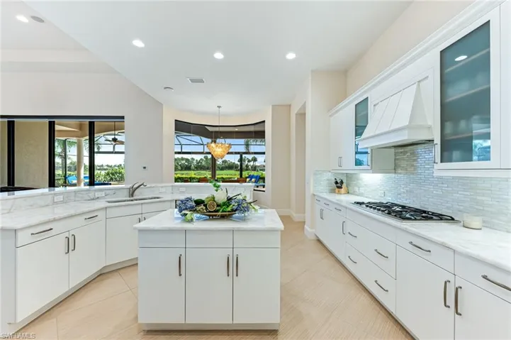 Kitchen featuring recessed lighting, backsplash, pendant lighting, white cabinets, and healthy amount of natural light