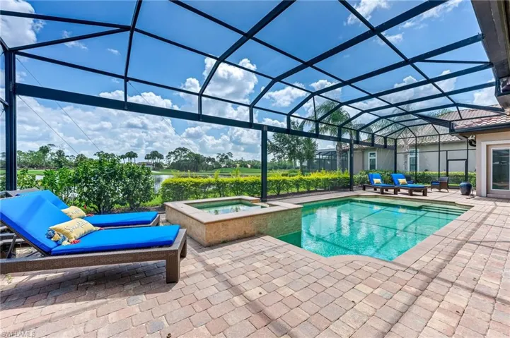 View of pool with a sunroom, a patio area, glass enclosure, and a pool with connected hot tub