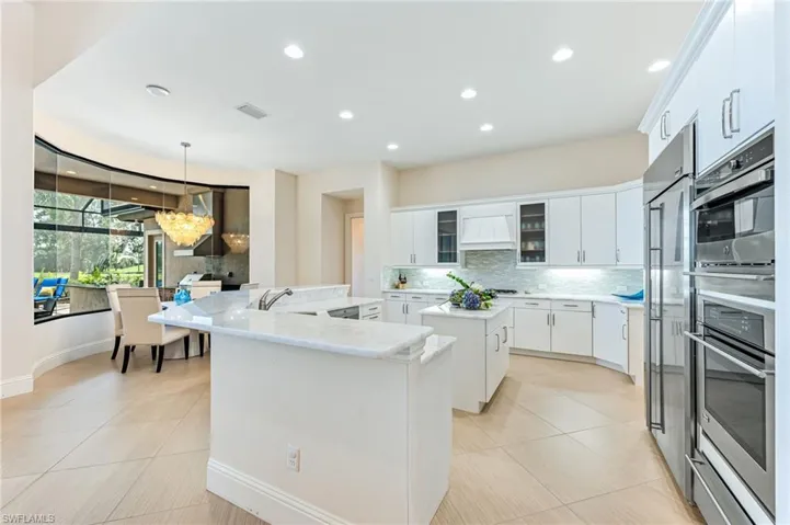 Kitchen featuring glass insert cabinets, decorative backsplash, hanging light fixtures, light tile patterned floors, and recessed lighting