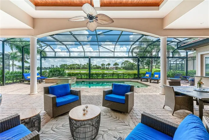 View of patio / terrace featuring a sunroom, glass enclosure, a pool with connected hot tub, outdoor lounge area, and a ceiling fan
